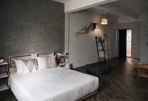 A modern bedroom with a large bed, bedside tables, a wardrobe, a ladder, and a hanging light fixture. - Realm Loft (Kaohsiung)