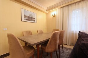A dining area with a table and chairs, a framed picture on the wall, and a window with curtains. - New Cairo,vast classy 3 BR Apt.in quite villa inside fruity garden. Guarded 24/7 (New Cairo City)