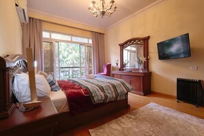 A bedroom with a bed, a TV, a dresser, a mirror, and a window. - New Cairo,vast classy 3 BR Apt.in quite villa inside fruity garden. Guarded 24/7 (New Cairo City)