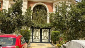 A two-story building with a central archway and a covered car in the foreground. - New Cairo,vast classy 3 BR Apt.in quite villa inside fruity garden. Guarded 24/7 (New Cairo City)