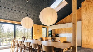 A modern kitchen with wooden cabinetry and a large island. - 5 Star Holiday Home in Saeby (Sæby)