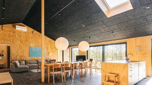 A modern interior with a dining area, kitchen, and seating space. - 5 Star Holiday Home in Saeby (Sæby)