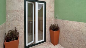 A building with a tiled roof, a glass door, and two potted plants. - AZZULEA Rossio Suite 2 (Lisboa)