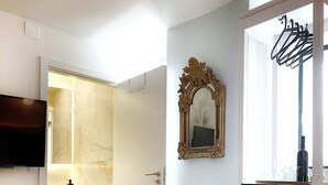 A hotel room with a bed, a TV, a mirror, a tray with food and drinks, and a bathroom visible through an open door. - AZZULEA Rossio Suite 2 (Lisboa)
