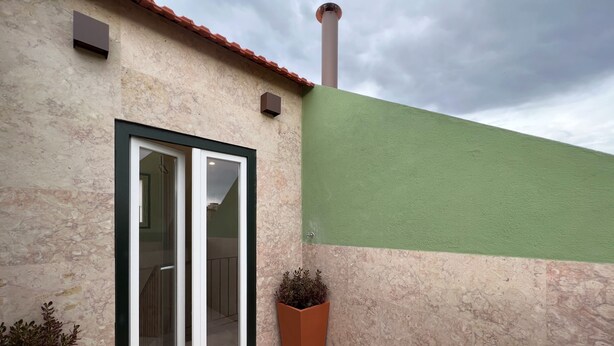 A building with a green wall, a tiled floor, and a window with a black frame. - AZZULEA Rossio Suite 2 (Lisboa)