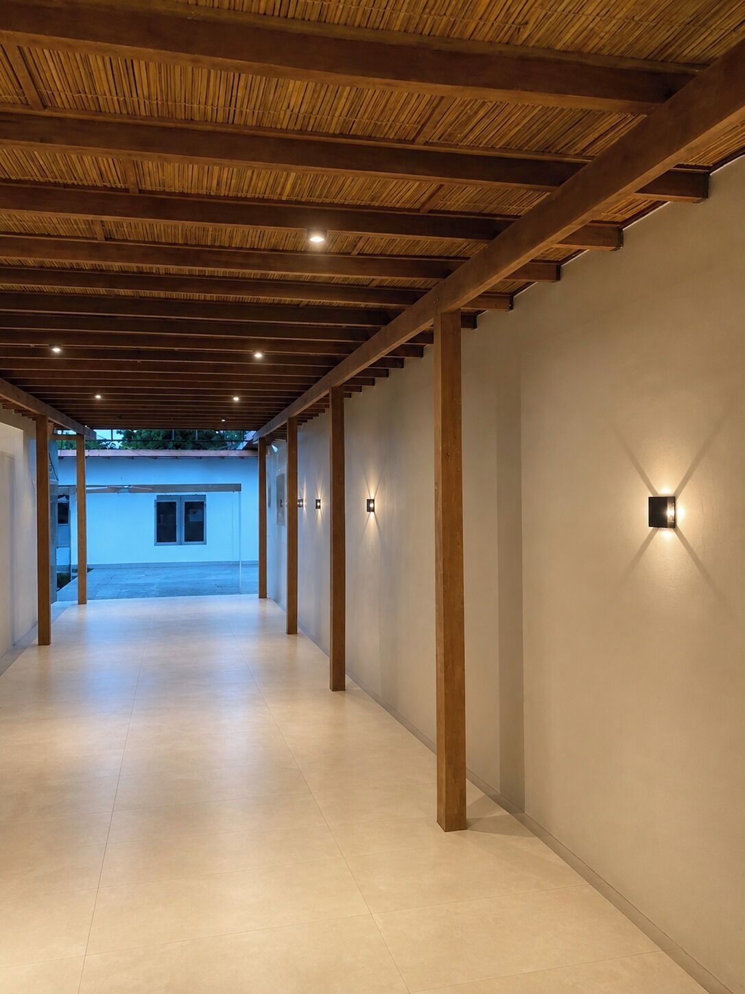 A corridor with wooden beams and recessed lighting.