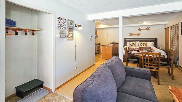 A compact living space with a sofa, a dining table, and a kitchen area. - King Studio / Hot Tubs, Pools & Ski Access (Panorama)