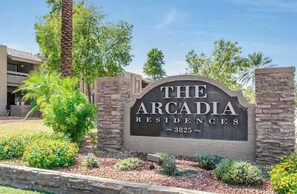 Une enseigne indiquant « The Arcadia Residences », avec une arche en pierre et le numéro « 3825 ».