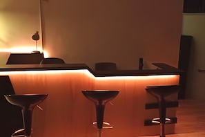 Eine Bar mit einer Theke und drei Hockern.