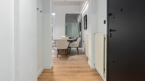 A hallway leading to a dining area with a table and chairs. - Luxury Glyfada flat steps from sea & main market (Glifada)
