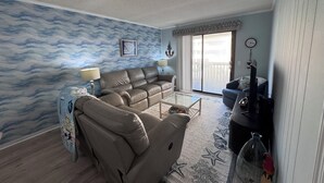 Ein Wohnzimmer mit einer Couch, einem Couchtisch und einem Fernseher.