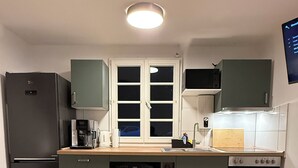 A compact kitchen with a refrigerator, dishwasher, microwave, and oven.