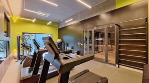 A gym with exercise equipment, a staircase, and a reception area. - Harmonia da Vila (São Paulo)
