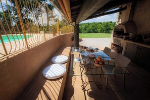 Ein Essbereich im Freien mit Tisch, Stühlen und Grill.