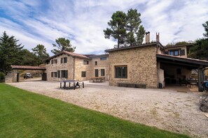 A stone building with a gravel driveway, a ping pong table, and a covered outdoor area. - 3.5-hectare private estate — heated pool, tennis and padel courts, sleeps 11 (Romans-sur-Isère)