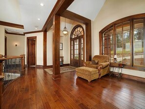 A spacious room with hardwood flooring, a large window, and a wooden chair. - Spectacular 4-bedroom house on beautiful Lake Wedowee (Wedowee)
