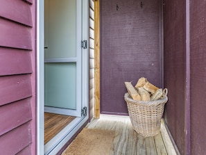 A wooden door with a basket of firewood beside it. - Mountainview Glimpse - Ohakune Holiday Home (Ohakune)