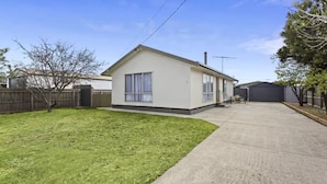 Yhden kerroksen talo, jossa on etupiha, autotalli ja pieni patio.