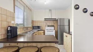 A kitchen with a large island, a microwave, a stove, and a refrigerator. - The Moorings Tides & Tails - Pets Welcome! (St Leonards)
