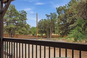 A fenced outdoor area with trees and a wooden structure. - Charming 1BR Studio with Full Kitchen (Prescott)