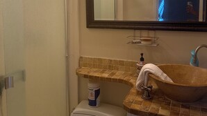 Ein Badezimmer mit Toilette, Waschbecken, Spiegel und Duschvorhang.