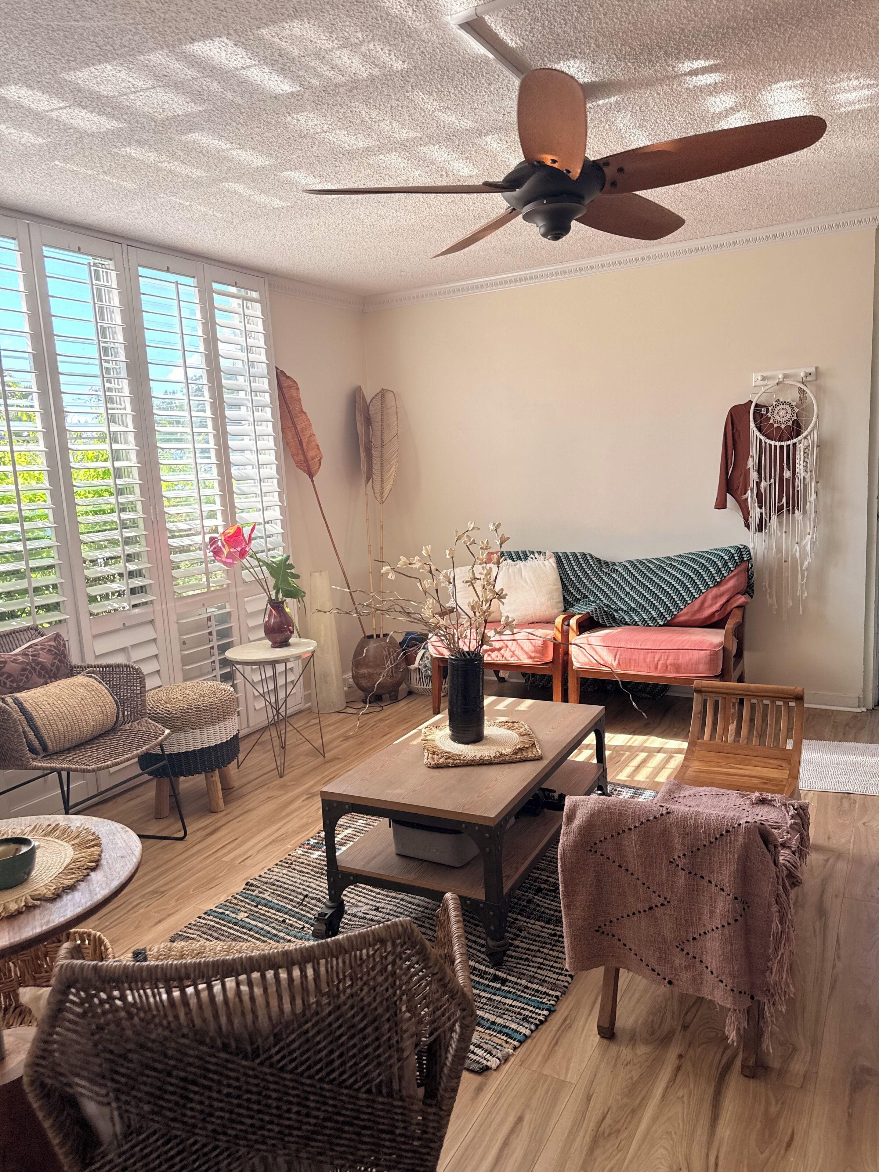 A living room with a ceiling fan, a sofa, a coffee table, and a dining area.