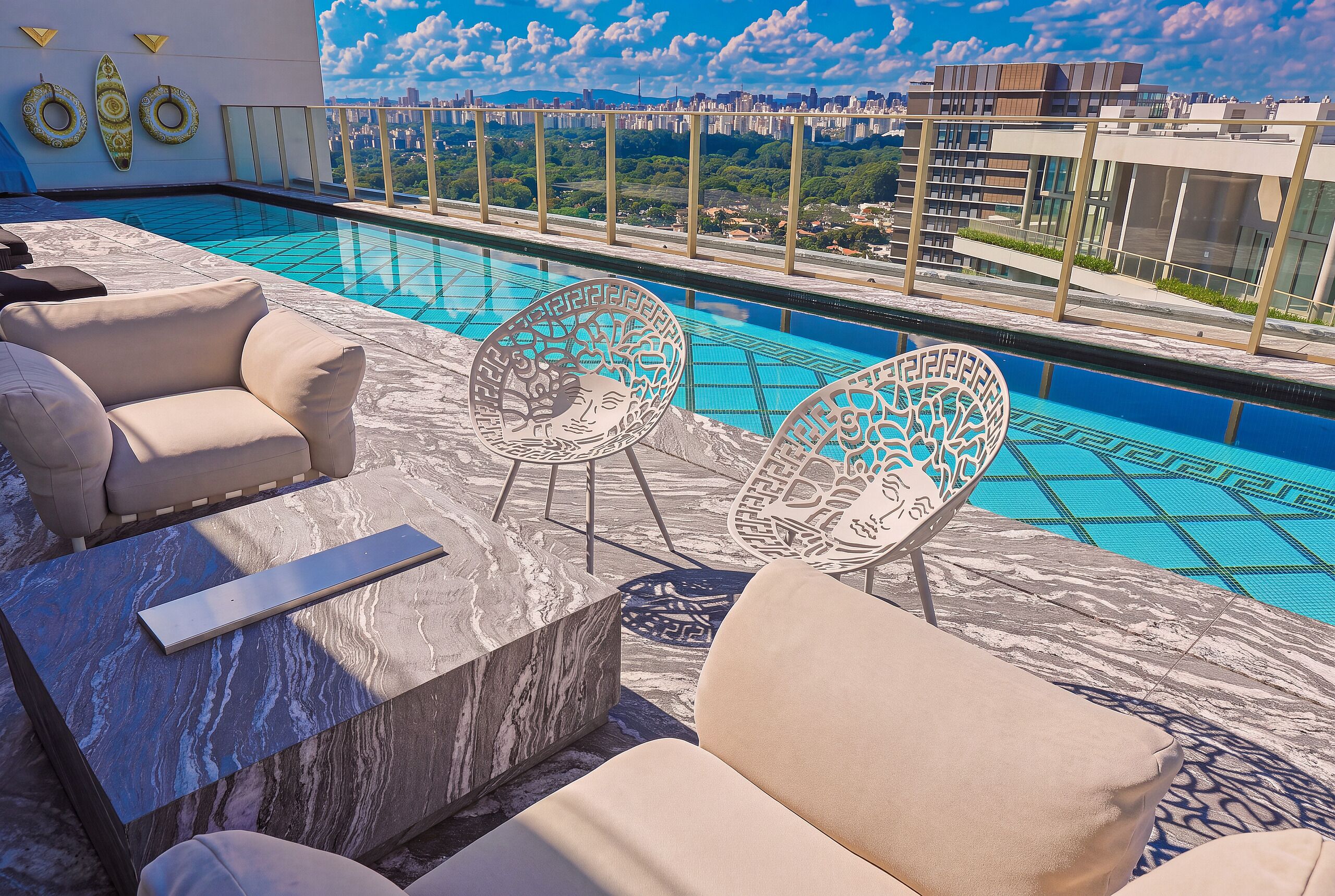 A rooftop pool area with lounge chairs and a bar.