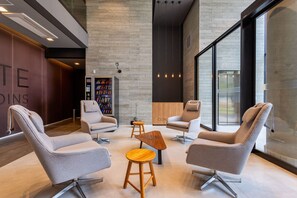 A modern interior with seating, a wooden coffee table, and a vending machine. - VN Capote Valente (São Paulo)