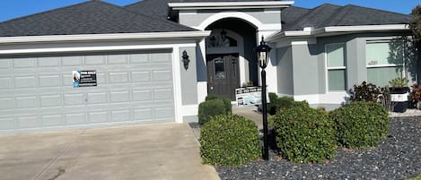 Una casa residencial con garaje, entrada principal y buzón.
