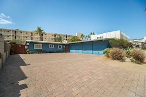 A courtyard with a blue building, a brick pathway, and a palm tree. - #D 1-level, 2Bd, 1block to Beach, Esplanade, Shops (Redondo Beach)