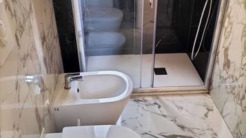 Un bagno con WC, bidet e doccia.