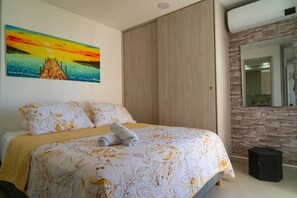 Ein Schlafzimmer mit Bett, Gemälde, Kleiderschrank, Spiegel und Lautsprecher.