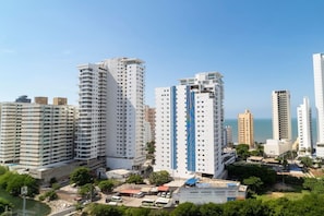 A high-rise residential building complex with multiple balconies, a parking area, and a view of the sea. - Golden Breeze Apartment • Beach • Seaview • Pool (Cartagena)