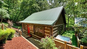 A log cabin with a metal roof, surrounded by a wooden deck and a hot tub. - Storybook Cabin-Hot Tub, Fire Pit & Tree Top Views (Ellijay)