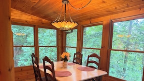A wooden dining room with a table, chairs, and a chandelier. - Storybook Cabin-Hot Tub, Fire Pit & Tree Top Views (Ellijay)