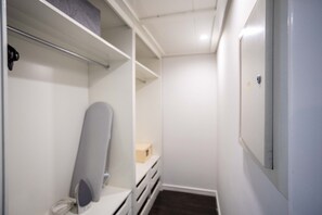 A narrow hallway with a white wall, a door on the right, and a shelf with a box on it. - Suite na Berrini by Conviva (São Paulo)