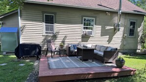 Una casa con patio amueblado con mobiliario exterior y una parrilla.