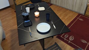 Una mesa de comedor con un modelo de barco, una radio y una planta.