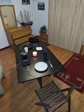 A dining table with a ship model, a radio, and a plant.