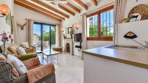 A spacious living area with a fireplace, a television, and a kitchen counter. - Villa rental in Moraira PONENT (Moraira)