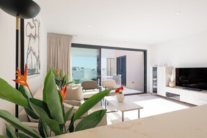 A modern living room with a sofa, chairs, a coffee table, and a TV. - Brand new 3 bedroom appartement at Santa Rosalia Lake & Life Resort (MC)
