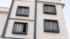A building with three windows and a sign for a restaurant named 'KUR' at the ground level. - Hotel Legacy Inn (Nagpur)