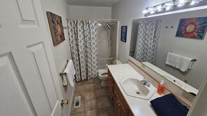 A bathroom with a shower, toilet, sink, and a mirror. - Glacier Octagon Haven -Cozy two bedroom escape near Glacier National Park (COLUMBIA FALLS)