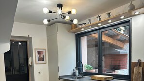A modern kitchen with a built-in oven, a window with a view, and a ceiling light fixture. - Villa with a Pool Nestled in the Esterel Mountains, 10 Minutes from the Beaches of Mandelieu and Cannes (Fréjus)
