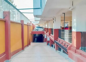 A corridor with a staircase, railings, and a covered area with a view of the outside. - Bosa Homes (Nairobi)
