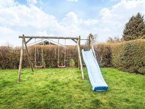 Ein Spielplatz mit Schaukeln und einer Rutsche.