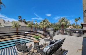 A rooftop patio with a pool, outdoor furniture, and palm trees. - The Vegas Retreat (Las Vegas)