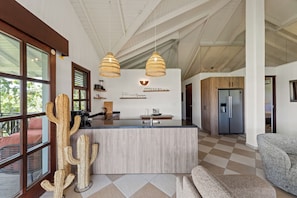 A modern kitchen with a central island, pendant lights, and a refrigerator. - The Village 52 Blue Bay Golf and Beach Resort (Blue Bay)