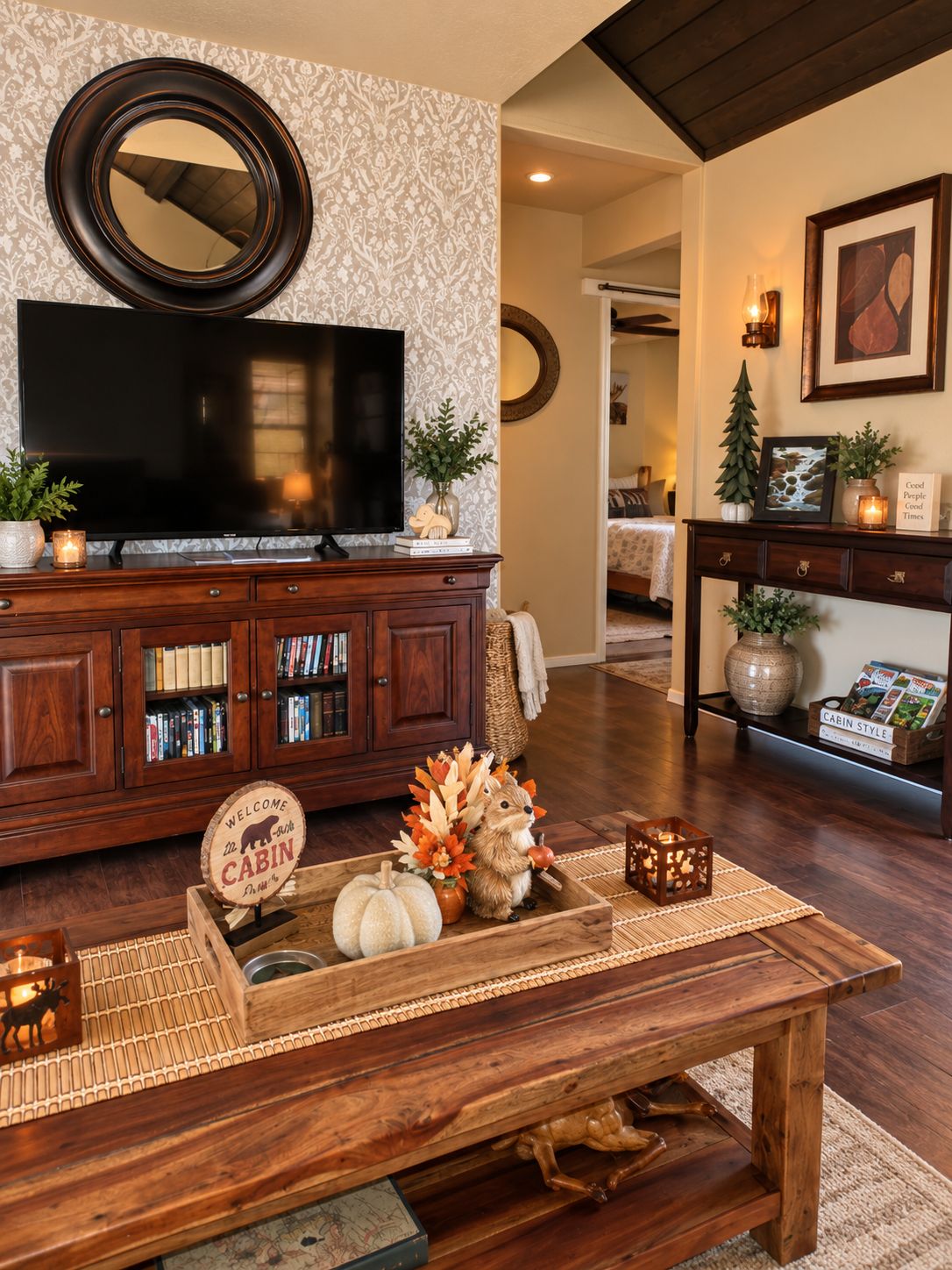 A living room with a flat-screen TV, a wooden coffee table with decorative items, a bookshelf, and a fireplace.