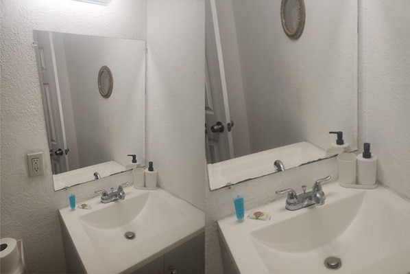 A bathroom with two sinks, mirrors, and toiletries. - Central Miami Studio | queen bed (Miami)